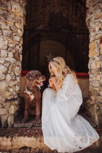 dow wearing flower crown around neck and pregnant blonde woman in white gown in stone temple