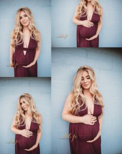 Maternity session locations featuring pregnant woman in deep burgundy dress against light blue textured wall, studio-style urban backdrop portraits
